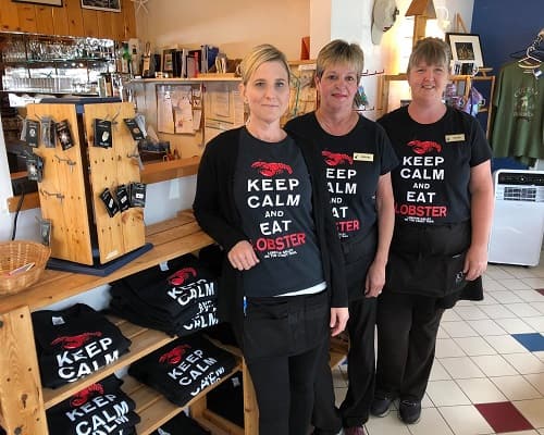 Three of the team in the gift shop wearing Keep Calm and Eat Lobster shirts