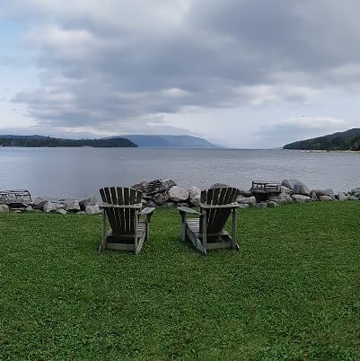 Adirondack chairs on the lawn facing the water