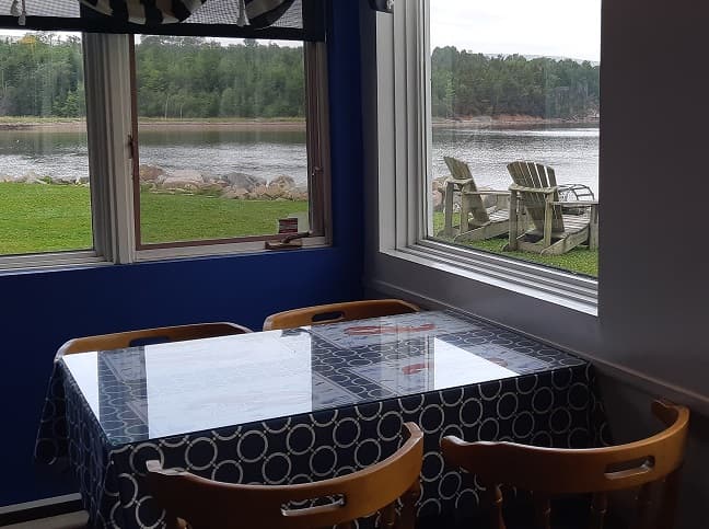 A corner table looking out to the lawn and the bay